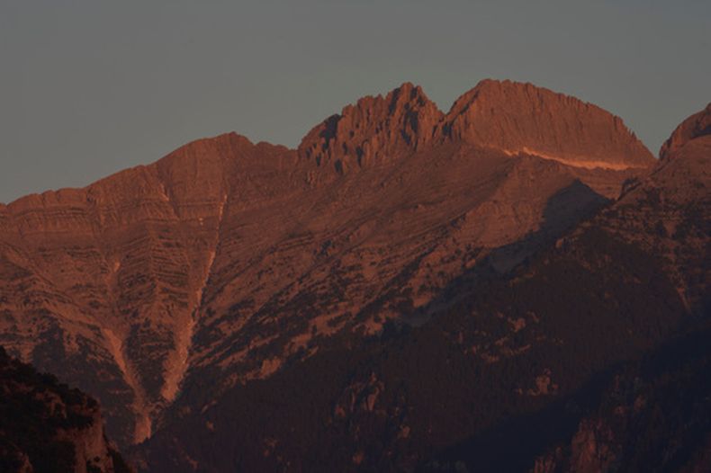 La luz de la mañana ilumina el Mytikas, el pico más alto de Grecia, en el centro a la izquierda, y el Stefani, conocido como el Trono de Zeus, en el centro a la derecha, en la cima del monte Olimpo, visto desde las afueras de Litochoro en el norte de Grecia, el miércoles 15 de julio de 2026. (AP Foto/Petros Giannakouris)