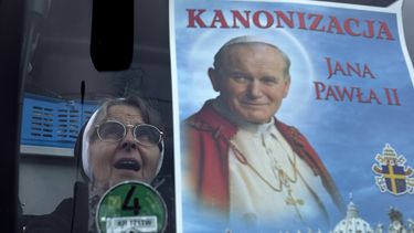 americateve | Una monja cat&oacute;lica gesticula luego de colocar un cartel del difunto papa Juan Pablo II en el parabrisas de un autob&uacute;s, en Wadowice, Polonia, el viernes 25 de abril de 2014. Dos autobuses partieron de Wadowice hacia Roma para que peregrinos p