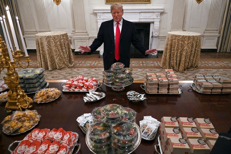 ARCHIVO - El presidente Donald Trump habla con periodistas sobre la mesa llena de comida rápida en el comedor de la Casa Blanca en Washington, el 14 de enero de 2019, para la recepción de los Tigres de Clemson. (AP Foto/Susan Walsh)