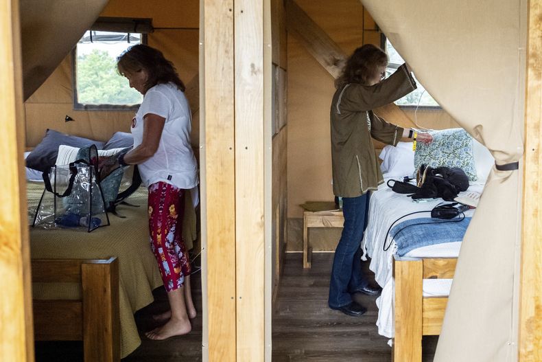 Beverly Cookie Grant, izquierda, y Ellen Shelburne desempacan dentro de su tienda de campaña de lujo en el Centro para las Artes Bethel Woods, sede de la Feria de Arte y Música de Woodstock, el viernes 14 de junio de 2024 en Bethel, Nueva York. (Foto AP/Julia Nikhinson)
