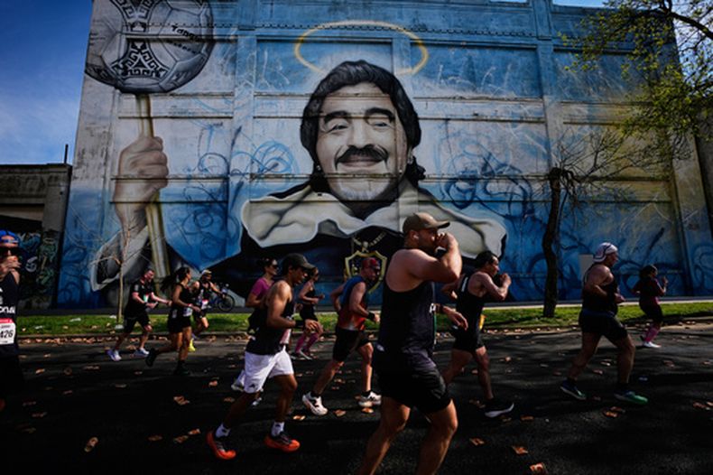Corredores pasan por delante de un mural con la imagen de Diego Maradona durante la maratón de Buenos Aires, en Argentina, el 20 de septiembre de 2026. (AP Foto/Natacha Pisarenko)