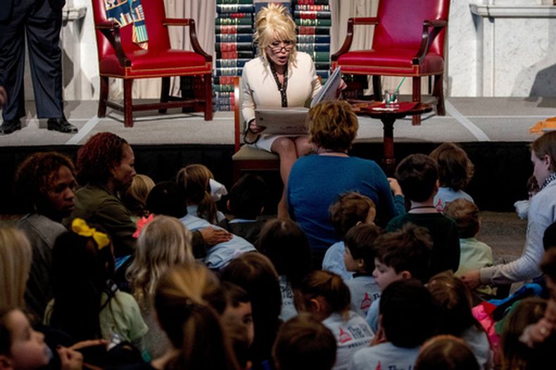 ARCHIVO - Dolly Parton lee su libro Coat of Many Colors en la Biblioteca del Congreso en Washington el 27 de febrero de 2018. (Foto AP/Andrew Harnik, archivo)