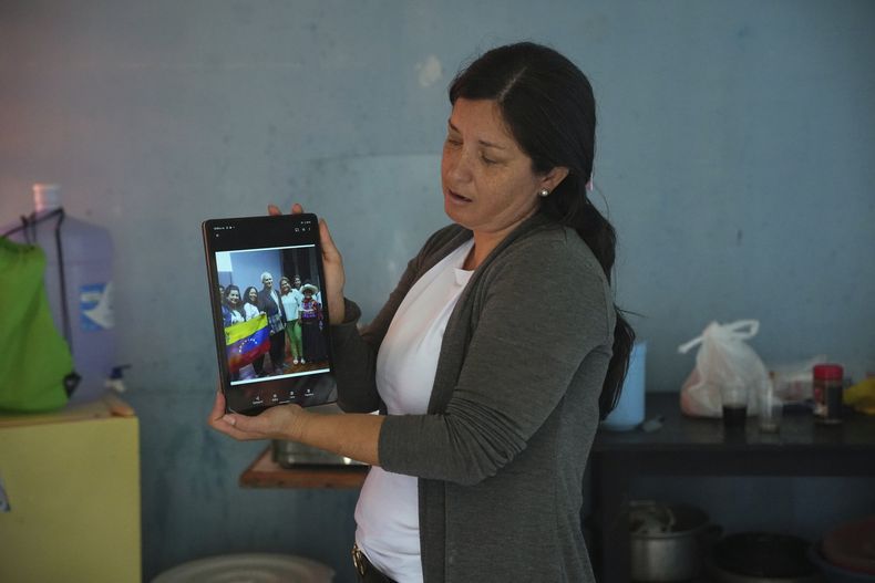 La venezolana Betania Rodríguez muestra con su tableta una foto grupal con el papa León XIV y el entonces obispo Robert Prevost en un albergue para migrantes administrado por Prevost y la Orden de San Vicente de Paúl en Chiclayo, Perú, el sábado 10 de mayo de 2025. (Foto AP/Guadalupe Pardo)