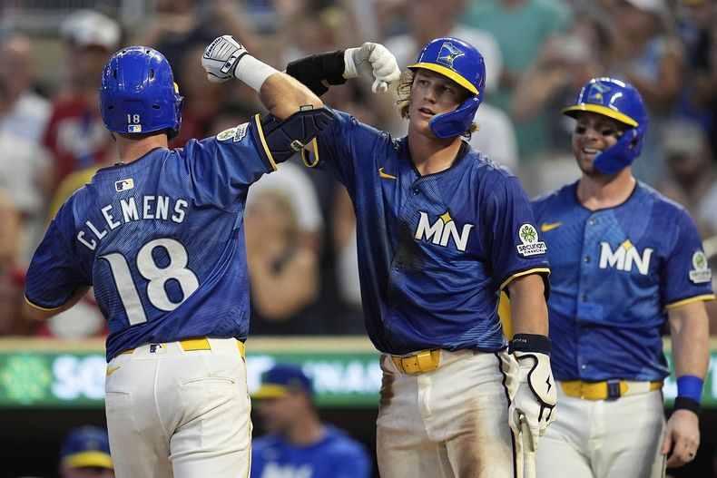 Kody Clemens (18), de los Mellizos de Minnesota, celebra con Luke Keaschall (15), centro, después de batear un cuadrangular solitario durante la cuarta entrada del juego de béisbol de Grandes Ligas frente a los Reales de Kansas City, el viernes 8 de agosto de 2025, en Minneapolis. (AP Foto/Abbie Parr)