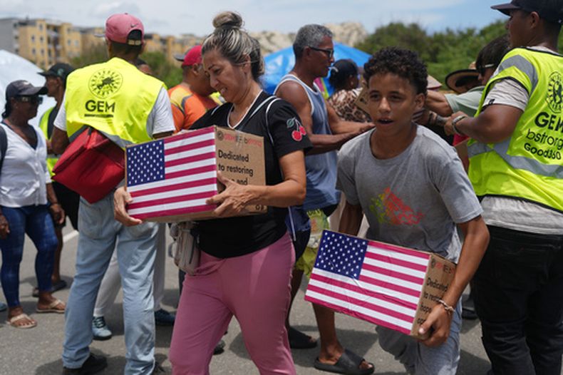 Personas afectadas por los terremotos llevan ayuda humanitaria enviad por EEUU, en La Guaira, Venezuela, el miércoles 8 de julio de 2026. (Foto AP/Ariana Cubillos)