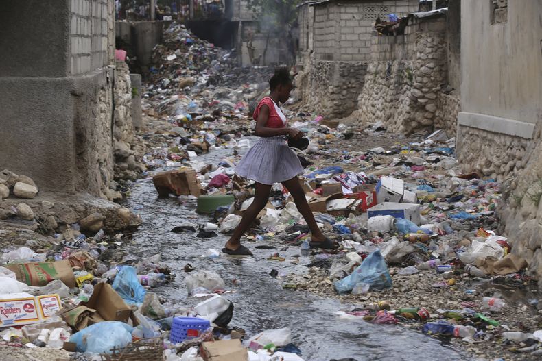 Una niña camina por una calle llena de basura en Puerto Príncipe, Haití, el jueves 13 de julio de 2023. (AP Foto/Odelyn Joseph)