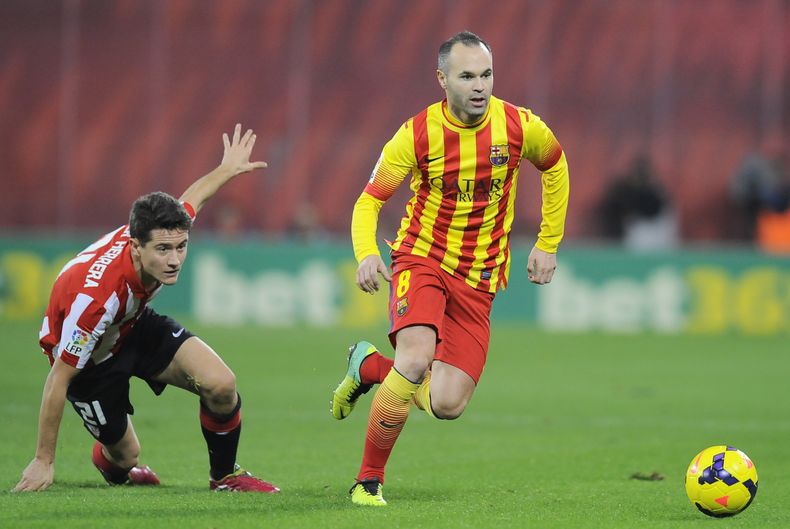 Andres Iniesta,derecha, de Barceliona, se escapa con el bal&oacute;n tras evadir la defensa de Ander Herrera, del Atl&eacute;tico de Bilbao, en un partido de La Liga el domingo, 1 de diciembre del 2013.  (Foto AP/Alvaro Barrientos)