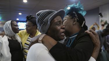 Marie Guillou, en primer plano a la izquierda, abraza a una feligresa en la Primera Iglesia Evangélica Haitiana de Springfield, el domingo 26 de enero de 2025, en Springfield, Ohio. (AP Foto/Jessie Wardarski)