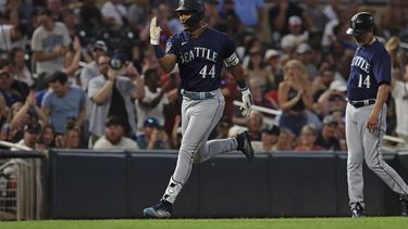 Julio Rodríguez (44) de los Marineros de Seattle avanza hacia el plato celebrando luego de conectar un cuadrangular en el octavo episodio del juego ante los Mellizos de Minnesota en Mineápolis. Martes 25 de julio de 2023.(AP Foto/Stacy Bengs)
