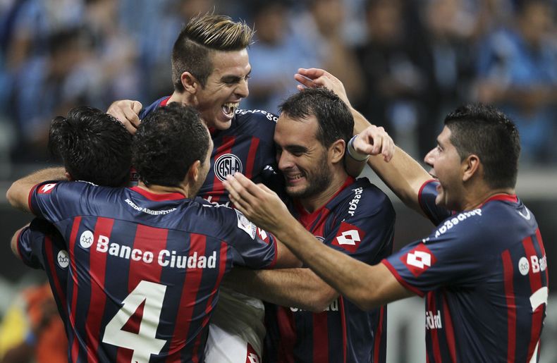 Julio Buffarini (arriba), del San Lorenzo de Argentina, festeja con sus compa&ntilde;eros tras vencer a Gremio de Brasil en la tanda de penales, en los cuartos de final de la Copa Libertadores, el mi&eacute;rcoles 30 de abril de 2014, en Porto Alegre (AP