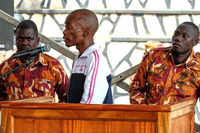 Christopher Okello Onyum, acusado de matar a cuatro niños, comparece en una corte temporal instalada en los terrenos de la iglesia comunitaria de Ggaba, en Kampala, Uganda, el lunes 13 de abril de 2026. (AP Foto/Hajarah Nalwadda)