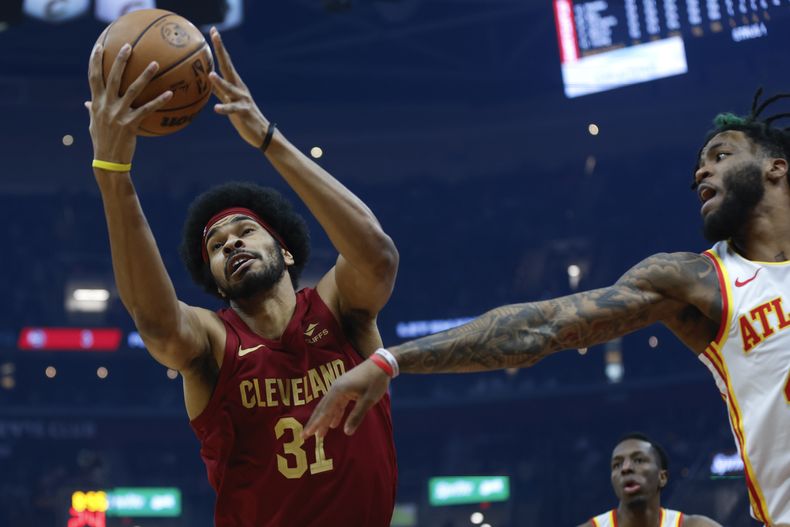 Jarrett Allen, pívot de los Cavaliers de Cleveland, atrapa un rebote junto a Saddiq Bey, alero de los Hawks de Atlanta, el sábado 16 de diciembre de 2023 (AP Foto/Ron Schwane)