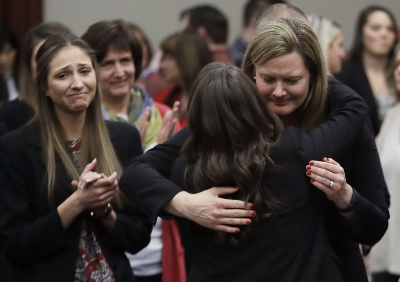 ARCHIVO - En esta foto del 24 de enero de 2018, las víctimas reaccionan y se abrazan con la fiscal adjunta Angela Povilaitis, luego que el doctor Larry Nassar fuera sentenciado a entre 40 y 175 años de prisión en Lansing, Michigan. (AP Foto/Carlos Osorio)