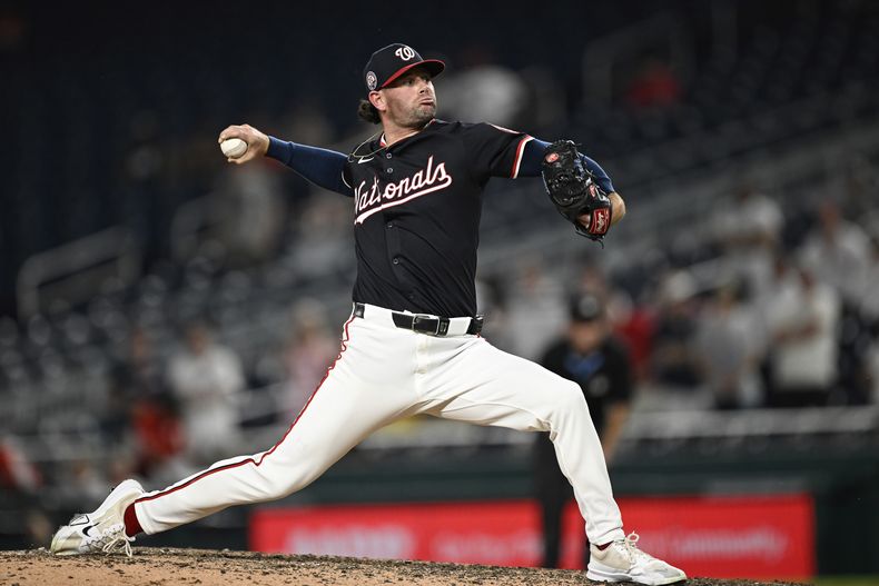El lanzador de los Nacionales de Washington, Kyle Finnegan, lanza durante la novena entrada de un partido de béisbol contra los Rojos de Cincinnati en Washington, el lunes 21 de julio de 2025. (AP Photo/Terrance Williams)