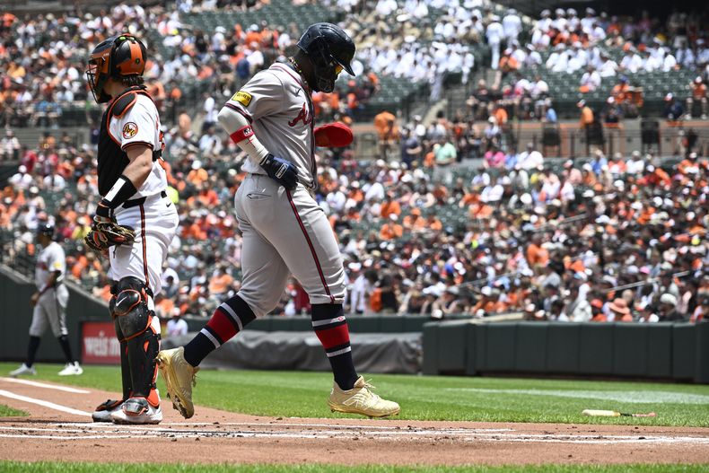 Michael Harris II (derecha) anota una carrera para los Bravos de Atlanta ante los Orioles de Baltimore, el jueves 13 de junio de 2024, en Baltimore. (AP Foto/Nick Wass)