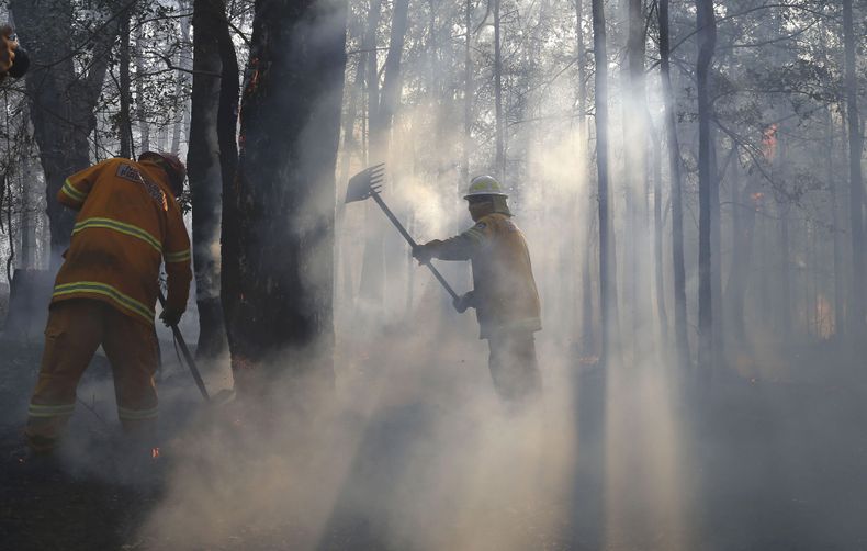 Dos bomberos tratan de controlar un incendio que arras&oacute; una propiedad en Bilpin, a 75 kil&oacute;metros de Sidney, el mi&eacute;rcoles 23 de octubre de 2013. Numerosas personas abandonaron el mi&eacute;rcoles sus viviendas en las monta&ntilde;as al