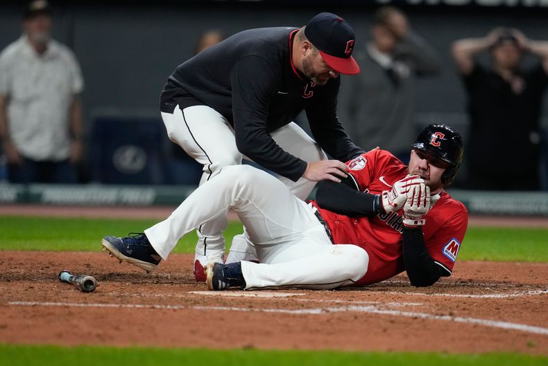 Stephen Vogt, manager de los Guardianes de Cleveland, atiende a David Fry, herido por un pelotazo durante el juego ante los Tigres de Detroit, el martes 23 de septiembre de 2025 (AP Foto/Sue Ogrocki)