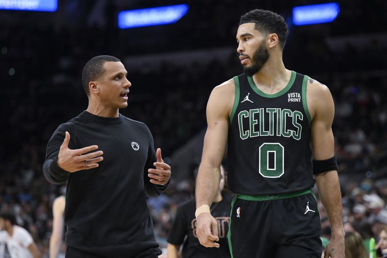El entrenador de los Celtics de Boston Joe Mazulla (izquierda) conversa con el alero de los Celtics Jayson Tatum durante la 2da mitad del juego de baloncesto de la NBA ante los Spurs de San Antonio, el domingo 31 de diciembre de 2023, en San Antonio. (AP Foto/Darren Abate)