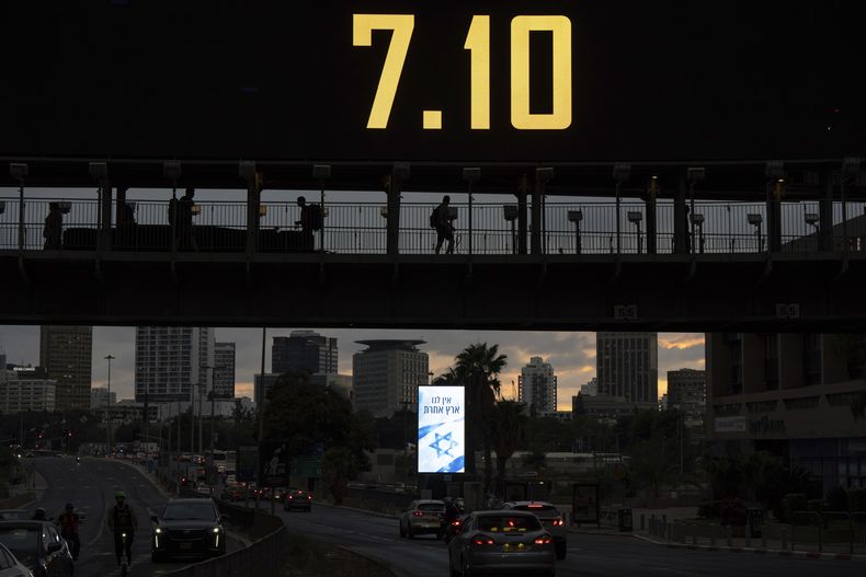 Gente cruzando un puente que muestra la fecha 7.10 en alusión al 7 de octubre, por el primer aniversario del ataque de Hamás a Israel, en Ramat Gan, Israel, el domingo 6 de octubre de 2024. (AP Foto/Oded Balilty)
