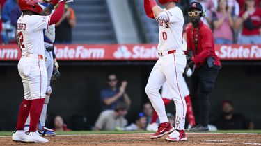 Kevin Newman, derecha, de los Angelinos de Los Ángeles, celebra luego de batear un jonrón durante la tercera entrada del juego de béisbol de Grandes Ligas contra los Rangers de Texas, el lunes 28 de julio de 2025, en Anaheim, California. (AP Foto/William Liang)