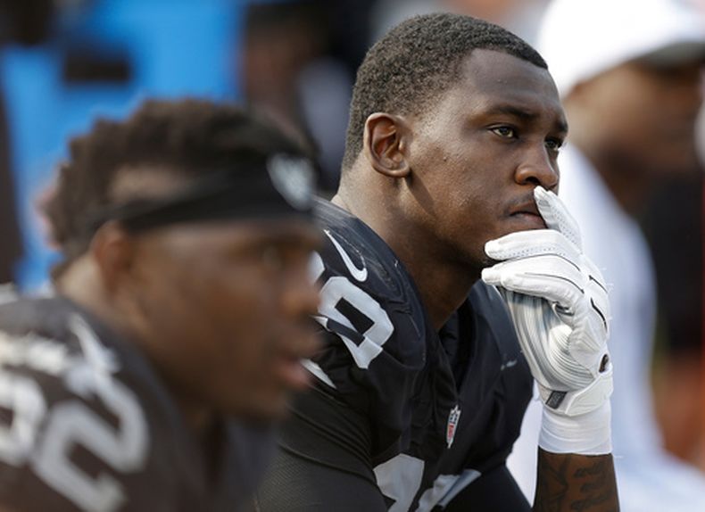 ARCHIVO - Aldon Smith (99), linebacker de los Raiders de Oaland, está pensativo en la banca durante la segunda mitad del partido de la NFL contra los Bengals de Cincinnati, el 13 de septiembre de 2015, en Oakland. (AP Foto/Ben Margot, Archivo)
