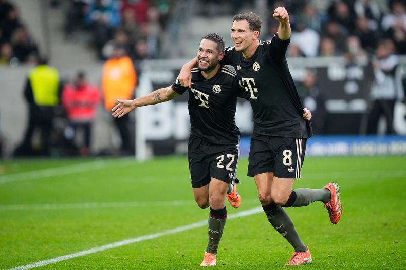 Raphael Guerreiro, de Bayern, a la izquierda, celebra con Leon Goretzka, de Bayern, después de anotar el segundo gol de su equipo durante el juego de fútbol de la Bundesliga Alemana entre Borussia Moenchengladbach y Bayern Munich en Moenchengladbach, Alemania, el sábado 25 de octubre de 2025. (AP Photo/Martin Meissner)