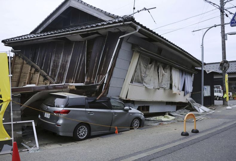 Un auto, aplastado por una vivienda que se derrumbó tras un potente sismo en la ciudad de Suzu, en la prefectura de Ishikawa, en el norte de Japón, el 5 de mayo de 2023. (Kyodo News vía AP)