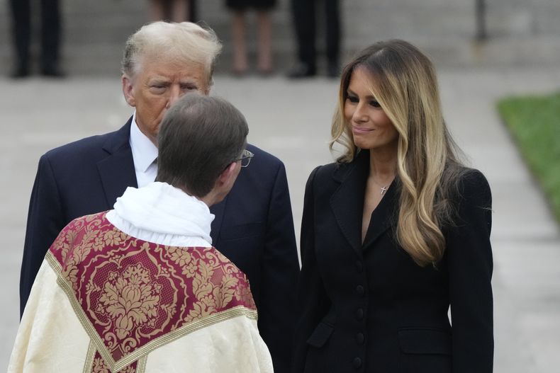 La ex primera dama Melania Trump, derecha, dialoga con un sacerdote acompañada por el expresidente Donald Trump luego del funeral de su madre, Amalija Knavs, el jueves 18 de enero de 2024, en la Iglesia de Bethesda-by-the-Sea en Palm Beach, Florida. (AP Foto/Rebecca Blackwell)