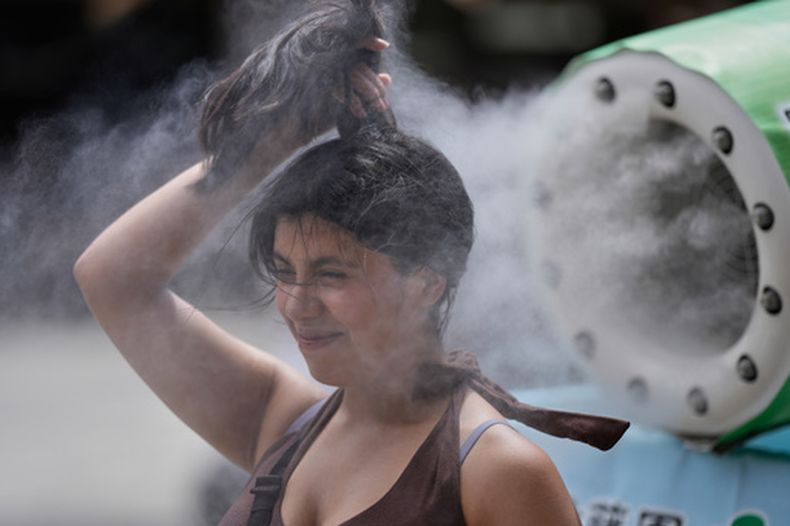 Una persona se refresca en una unidad de enfriamiento durante un caluroso día en el templo budista Sensoji, el 7 de agosto de 2026, en el distrito de Asakusa, en Tokio. (AP Foto/Eugene Hoshiko, Archivo)