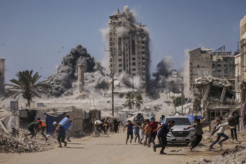 ARCHIVO - Palestinos corren a cubrirse durante un ataque israelí contra un edificio alto en Ciudad de Gaza, el viernes 5 de septiembre de 2025, después de que el Ejército israelí emitiera una advertencia. (AP Foto/Yousef Al Zanoun, Archivo)