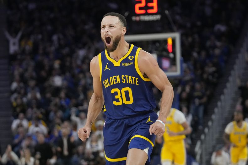 Stephen Curry, base de los Warriors de Golden State, festeja luego de acertar un triple frente a los Lakers de Los Ángeles, el jueves 22 de febrero de 2024 (AP Foto/Jeff Chiu)