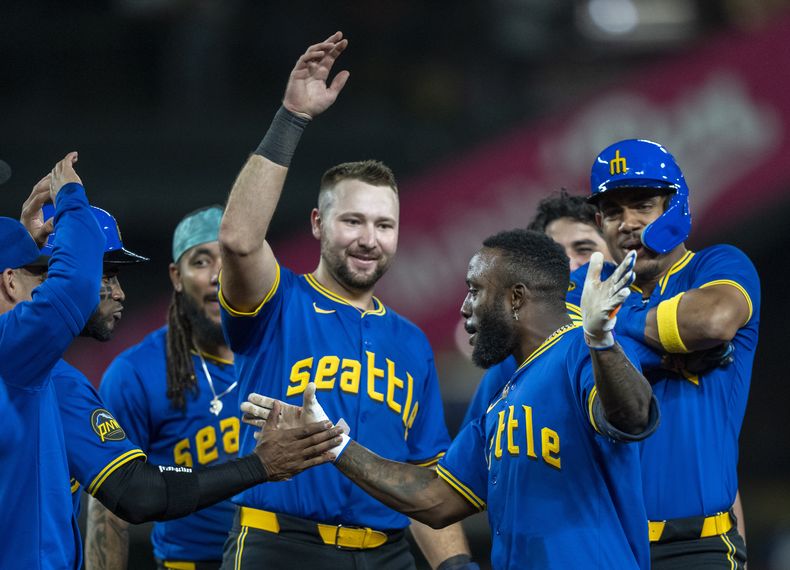 Randy Arozarena de los Marineros de Seattle, tercero desde la derecha, celebra con compañeros de equipo como Víctor Robles, segundo desde la izquierda, J.P. Crawford, tercero desde la izquierda, Cal Raleigh, centro, y Julio Rodríguez, a la derecha, contra los Rangers de Texas, el sábado 14 de septiembre de 2024, en Seattle. (AP Foto/Stephen Brashear)