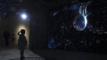Una niña mira un vídeo que representa el universo de ciencia ficción de una trilogía del autor chino Liu Cixin en Chengdu, provincia de Sichuan, el sábado 21 de octubre de 2023. La serie que comenzó con El problema de los tres cuerpos ayudó a la ciencia ficción china a abrirse paso a nivel internacional, ganando premios y llegando a las listas de lectura de personas como el ex presidente estadounidense Barack Obama y Mark Zuckerberg. (Foto AP/Ng Han Guan)