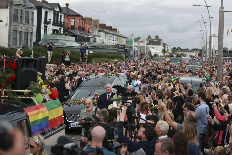 Fans de Sinéad OConnor rodean su cortejo fúnebre en Bray, la ciudad natal de la cantante en el condado de Wicklow, Irlanda, el martes 8 de agosto de 2023. La familia de OConnor invitó al público al paseo marítimo de Bray para despedirse de la artista.(Liam McBurney/ PA vía AP)