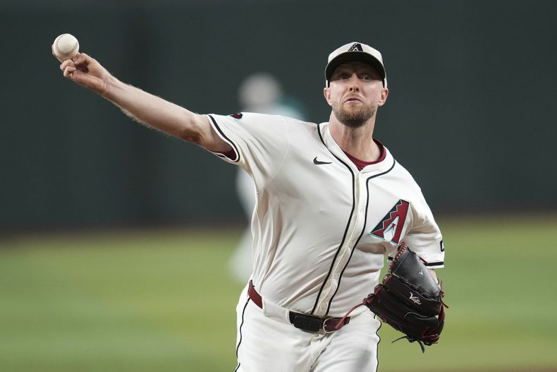 El lanzador abridor de los Diamondbacks de Arizona, Merrill Kelly, calienta antes de un juego contra los Rockies de Colorado, el domingo 18 de mayo de 2025, en Phoenix. (AP Foto/Ross D. Franklin)