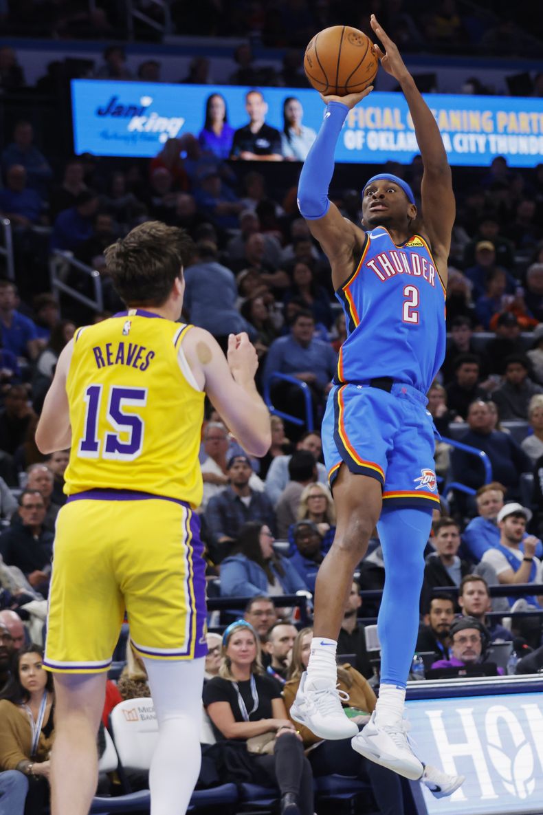 El base del Thunder de Oklahoma City Shai Gilgeous-Alexander lanza el balón frente a Austin Raves de ls Lakers de Los Ángeles en el encuentro del jueves 30 de noviembre del 2023. (AP Foto/Nate Billings)