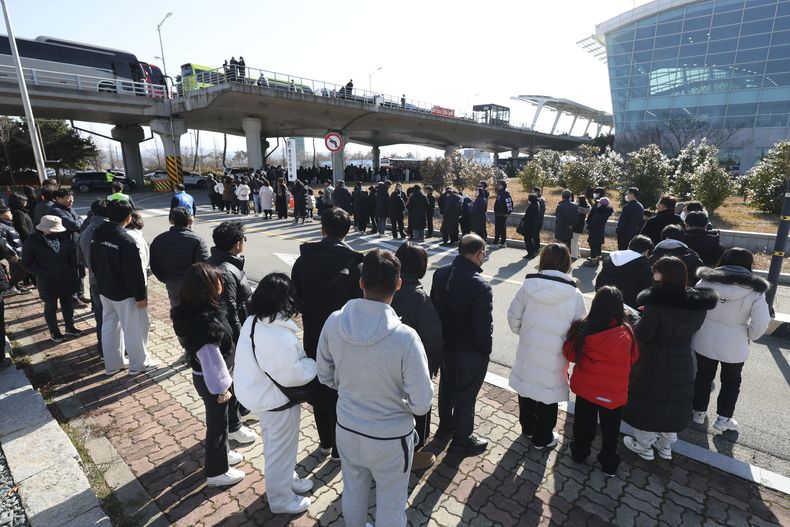 Dolientes esperan a rendir homenaje a las víctimas de un accidente aéreo en un altar de recuerdo en el Aeropuerto Internacional de Muan, en Muan, Corea del Sur, el miércoles 1 de enero de 2025. (Kim Sun-woong/Newsis via AP)
