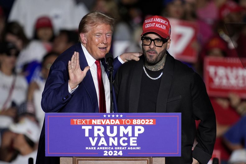 El expresidente Donald Trump, candidato presidencial republicano, a la izquierda, saluda a Nicky Jam durante un evento de campaña en el World Market Center, el viernes 13 de septiembre de 2024, en Las Vegas. (Foto AP/John Locher)