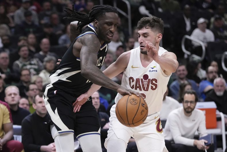 Ty Jerome, de los Cavaliers de Cleveland, golpea el balón de Taurean Prince, de los Bucks de Milwaukee, durante la primera mitad de un partido de baloncesto de la NBA, el domingo 9 de marzo de 2025, en Milwaukee. (AP Foto/Morry Gash)
