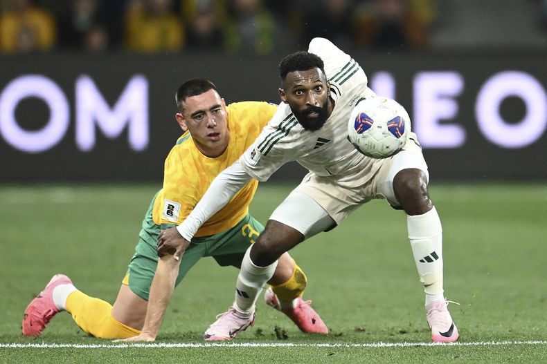 El australiano Lewis Miller pelea por el balóncon el saudí Feras Albrikan en el duelo de la eliminatoria al Mundial2 026 el jueves 14 de noviembre del 2024. (Joel Carrett/AAP Image via AP)
