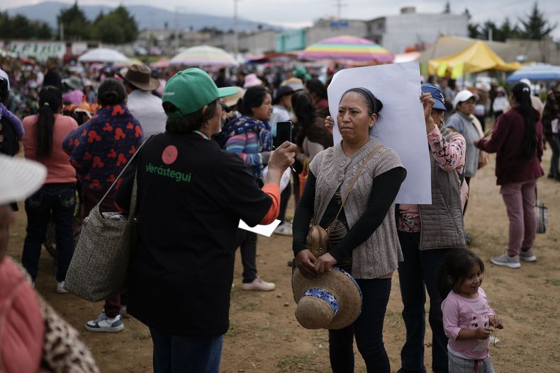 Un miembro del equipo de campaña del aspirante presidencial Eduardo Verástegui toma una fotografía de un firmante durante una manifestación para recolectar firmas que permitan a Verástegui postularse como candidato independiente en las elecciones presidenciales de 2024, en San Bartolo del Valle, México, el viernes 10 de noviembre de 2023. El aspirante de derecha de 49 años ha provocado controversia en esta nación profundamente católica, donde los activistas del aborto y la comunidad LGBTQ+ lideran sus propias campañas en defensa de sus derechos. (Foto AP/Eduardo Verdugo)