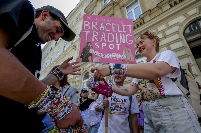 Swifties intercambian brazaletes de la amistad en el cetro de Viena el 8 de agosto de 2024. Los organizadores de tres conciertos de Taylor Swift en un estadio de Viena los cancelaron el miércoles después de dos arrestos por un aparente complot para realizar un ataque contra un evento masivo en el área de Viena como los conciertos. (Foto AP/Heinz-Peter Bader)