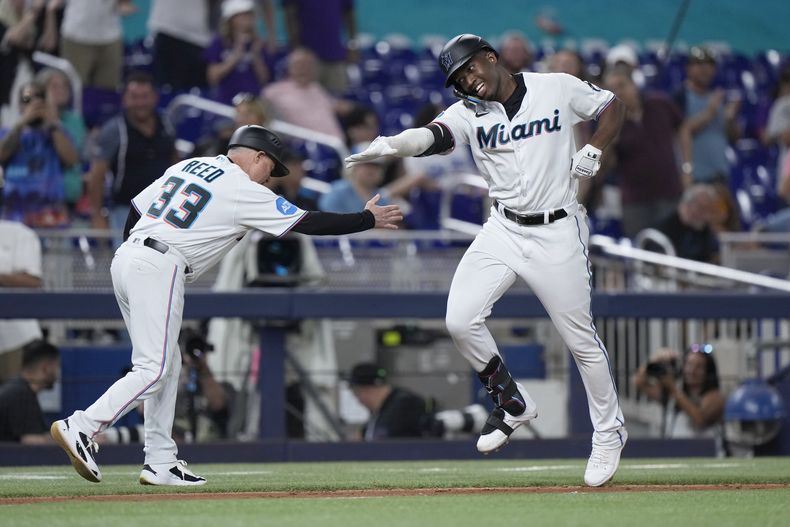 Jesús Sánchez, derecha, de los Marlins de Miami, celebra con el coach de tercera, Jody Reed (33), después de que Sánchez bateara un cuadrangular durante la quinta entrada del juego de béisbol en contra de los Dodgers de Los Ángeles, el miércoles 6 de septiembre de 2023, en Miami. (AP Foto/Wilfredo Lee)
