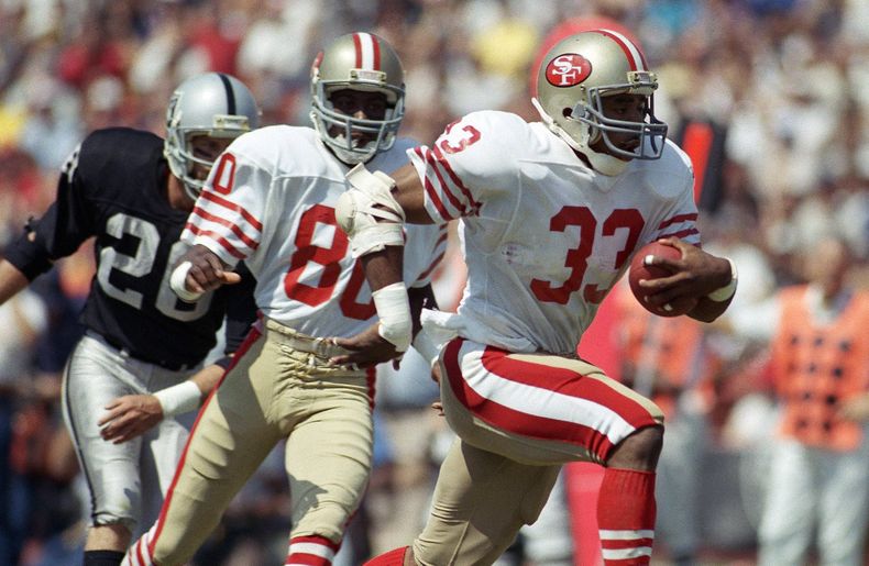 ARCHIVO - Foto del 22 de septiembre de 1985, Roger Craig de los 49ers de San Francisco avanza a la línea de anotación en el encuentro ante los Raiders de Los Ángeles. (AP Foto/Doug Pizac, Archivo)