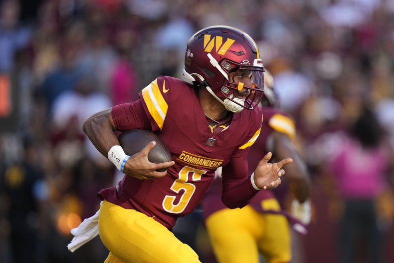 El quarterback de los Commanders de Washington, Jayden Daniels, lleva el balón en la primera mitad del partido ante los Panthers de Carolina, el domingo 20 de octubre de 2024, en Landover, Maryland. (AP Foto/Stephanie Scarbrough)