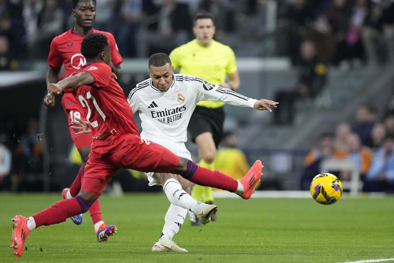 El francés Kylian Mbappé, del Real Madrid, anota en un partido de La Liga ante el Sevilla, el domingo 22 de diciembre de 2024 (AP Foto/Bernat Armangue)