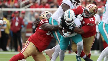 DeVon Achane, al centro, de los Dolphins de Miami, corre mientras CJ West, izquierda, y Gracen Halton (93), tackles defensivos de los 49ers de San Francisco buscan derribarlo durante la primera mitad del partido de la NFL del domingo 20 de septiembre de 2026, en Santa Clara, California. (AP Foto/Jed Jacobsohn)