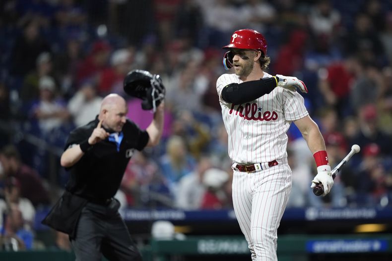 Bryce Harper, derecha, de los Filis de Filadelfia, reacciona luego de ser expulsado por el umpire de home, Mike Estabrook, después de ser ponchado en la séptima entrada del juego de béisbol en contra de los Mets de Nueva York, el viernes 23 de junio de 2023, en Filadelfia. (AP Foto/Matt Slocum)
