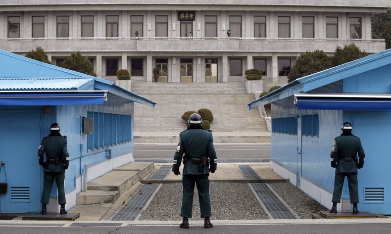 Un soldado norcoreano, centro arriba, mira la zona sur vigilada por tres soldados surcoreanos en la aldea fronteriza de Panmunjom, en Paju, al norte de Se&uacute;l, Corea del Sur, el mi&eacute;rcoles 12 de marzo del 2014. (Foto AP/Lee Jin-man)