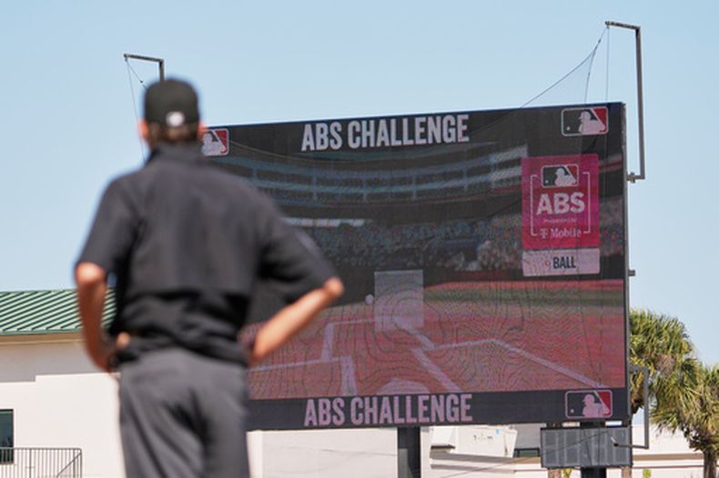 El umpire Ryan Additon observa la pantalla luego de que una llamada fuera retada usando el Sistema Automatizado de Bolas/Strikes durante la tercera entrada del partido de entrenamientos de primavera entre los Marlins de Miami y los astros de Houston el miércoles 25 de febrero de 2026, en Jupiter, Florida. (AP Foto/Jeff Roberson)